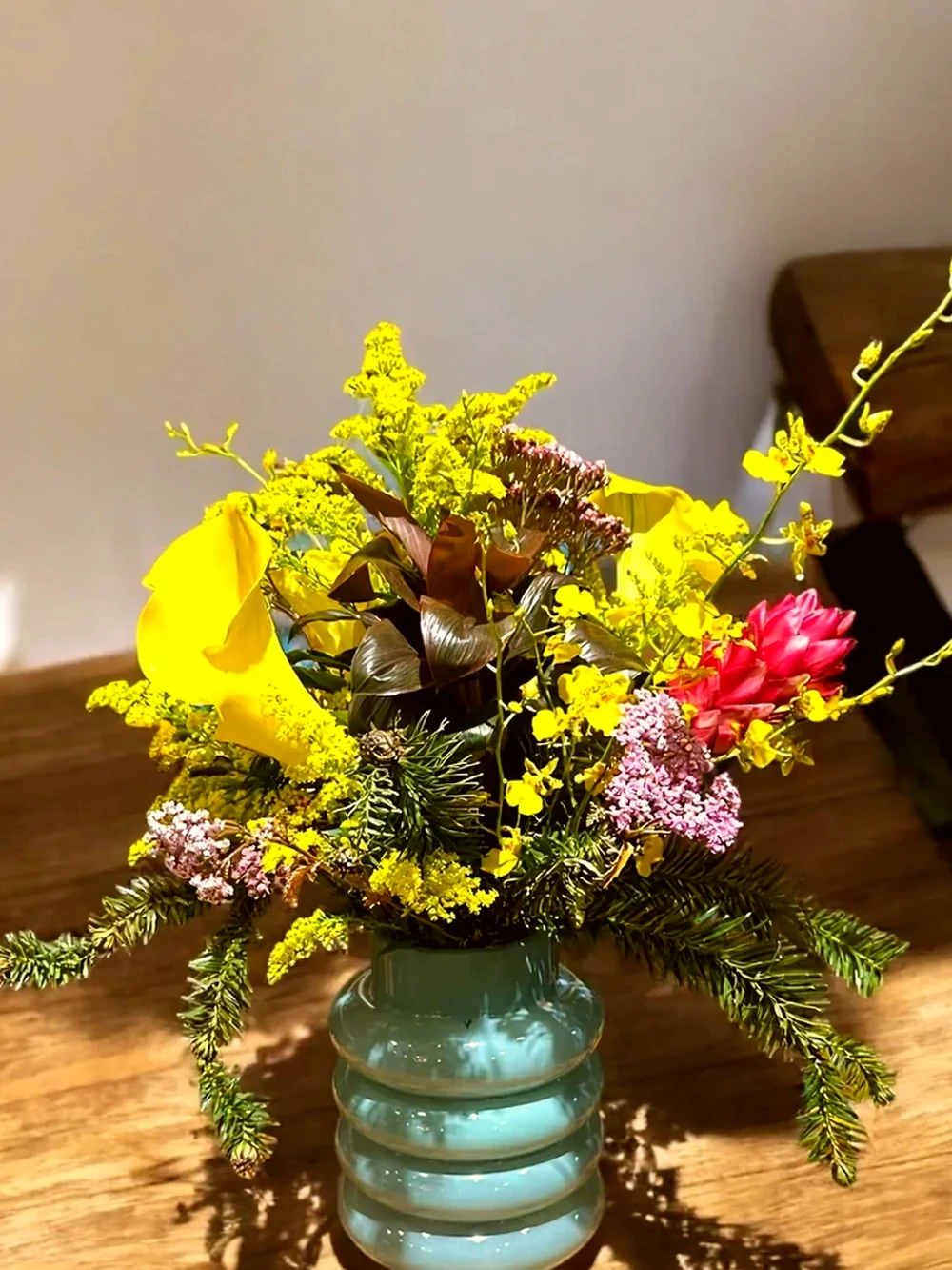 Arranjo Floral com Callas Amarelas e Flores Tropicais no Vaso de Vidro Azul